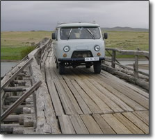 Mongolian 4x4 crossing a rickety bridge